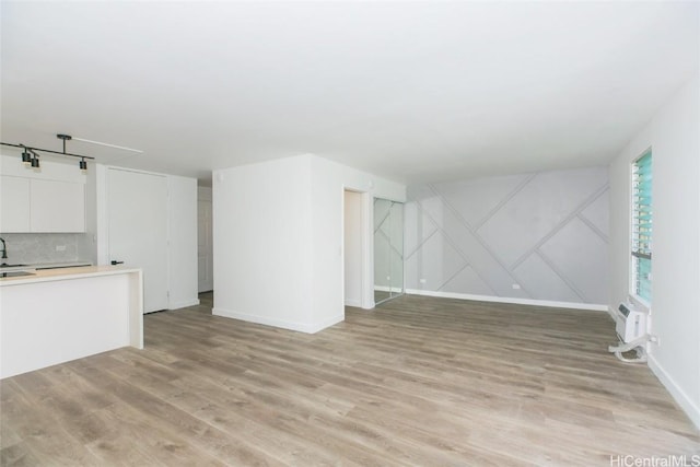 unfurnished living room featuring light wood-style flooring and baseboards