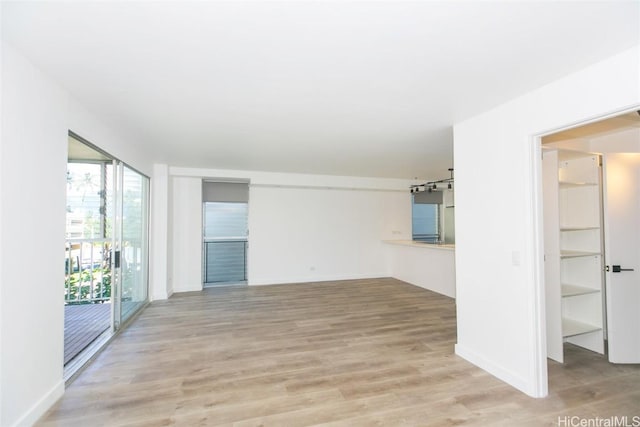 spare room featuring light wood finished floors and baseboards