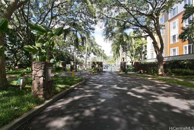 view of road featuring curbs, a gated entry, and a gate