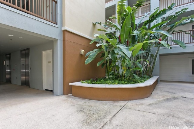 exterior space with elevator and stucco siding