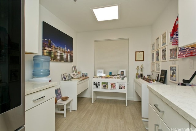 home office with light wood-type flooring and baseboards