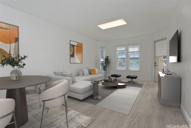 living area with light wood-style floors and baseboards