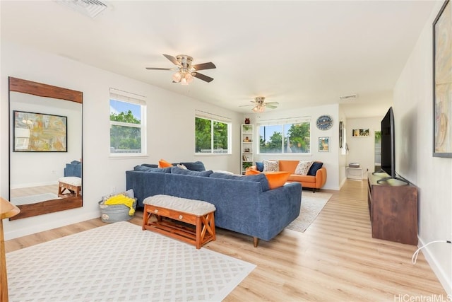 living area with visible vents, baseboards, a ceiling fan, and light wood finished floors