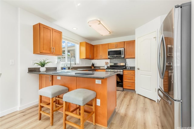 91-1259 Kilipue St Unit 2901, Ewa Beach, HI 96706 - kitchen with stainless steel appliances, a sink, light wood-style floors, and a breakfast bar