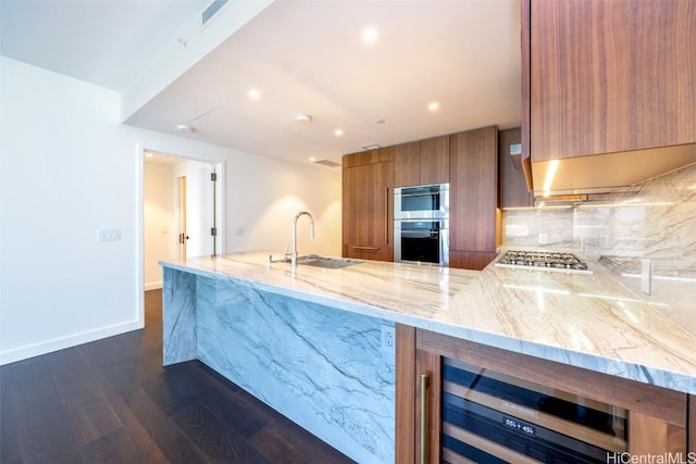 kitchen with wine cooler, modern cabinets, brown cabinetry, and a sink