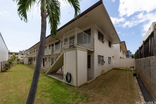 view of side of home featuring a yard and fence