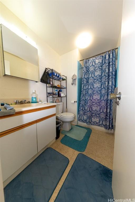 full bathroom featuring toilet, vanity, and a shower with curtain