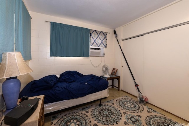 bedroom with concrete block wall and cooling unit