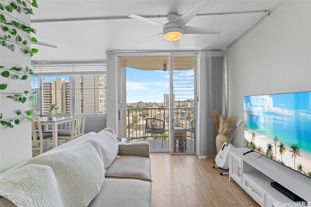 living room featuring ceiling fan, wood finished floors, and expansive windows