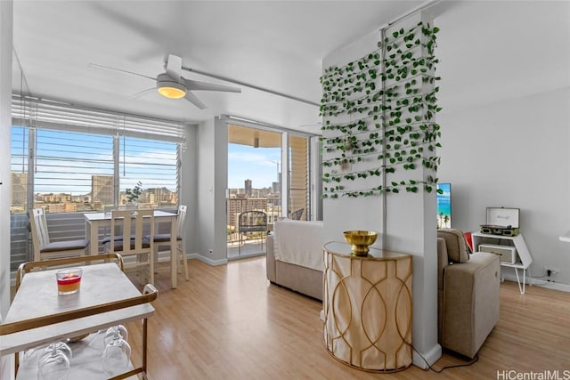 bedroom featuring a view of city, access to outside, light wood-style flooring, and baseboards