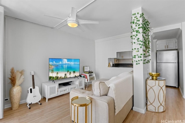 living area with light wood-type flooring, a ceiling fan, and crown molding