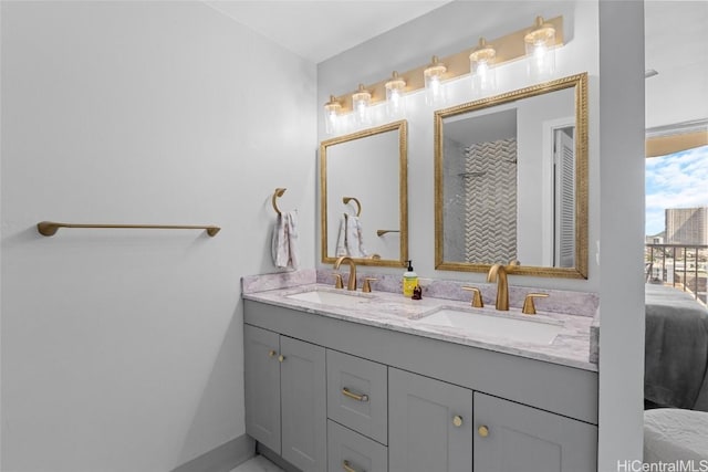 bathroom featuring ensuite bath, double vanity, and a sink