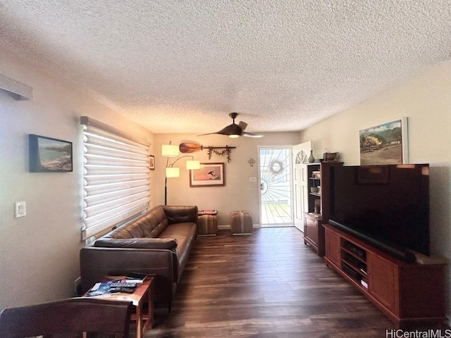 living room with a ceiling fan, dark wood finished floors, a textured ceiling, and baseboards