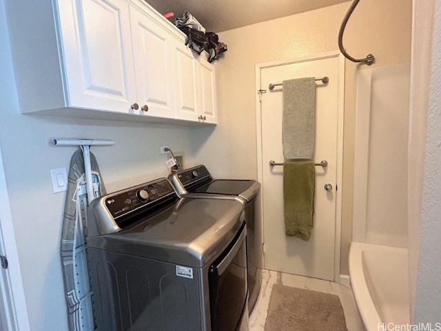 clothes washing area featuring cabinet space and washing machine and clothes dryer