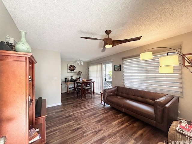 living area featuring dark wood-style floors, ceiling fan, a textured ceiling, and baseboards