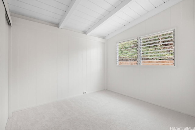 empty room featuring vaulted ceiling with beams and carpet