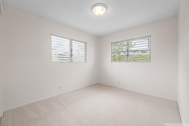 unfurnished room with a textured ceiling and carpet floors