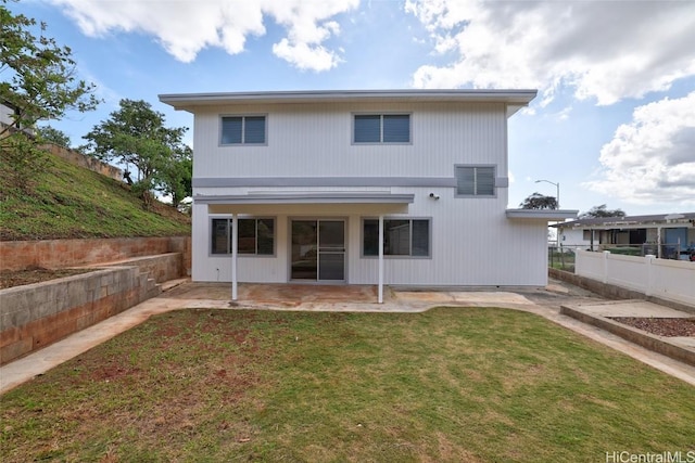 rear view of property with a patio, a lawn, and fence