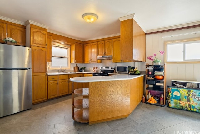 kitchen featuring brown cabinetry, stainless steel appliances, light countertops, under cabinet range hood, and a sink