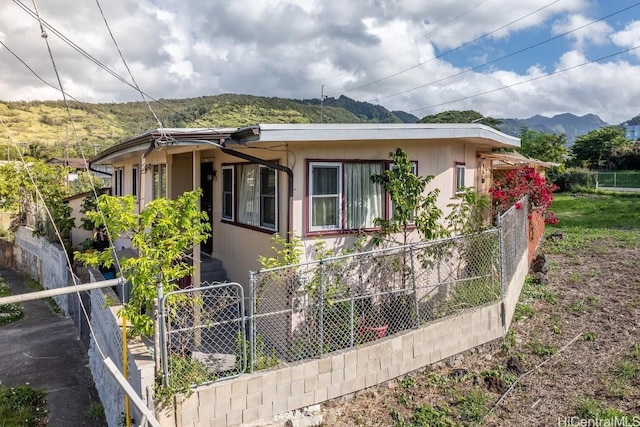 view of front facade featuring a gate, fence, and a mountain view