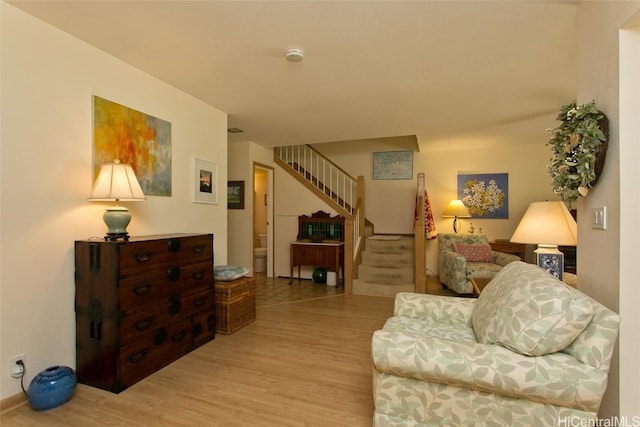 living room featuring light wood-style flooring and stairs