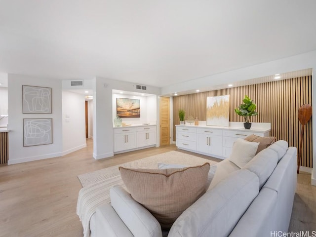 living room featuring visible vents, baseboards, and light wood-style floors