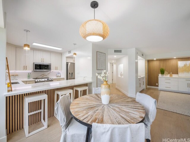 dining area featuring light wood finished floors and visible vents