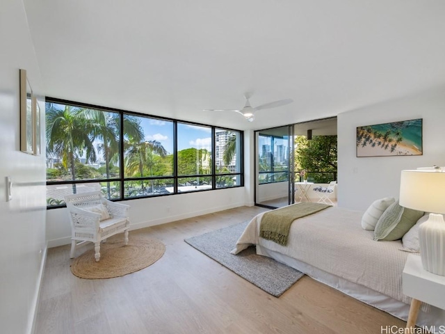 bedroom with access to exterior, baseboards, and wood finished floors