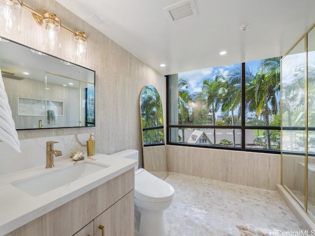 bathroom with a wealth of natural light, visible vents, vanity, and toilet