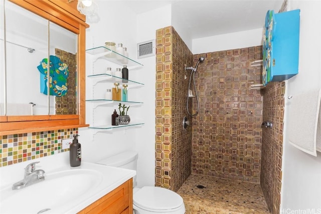 full bathroom featuring visible vents, backsplash, toilet, tiled shower, and vanity