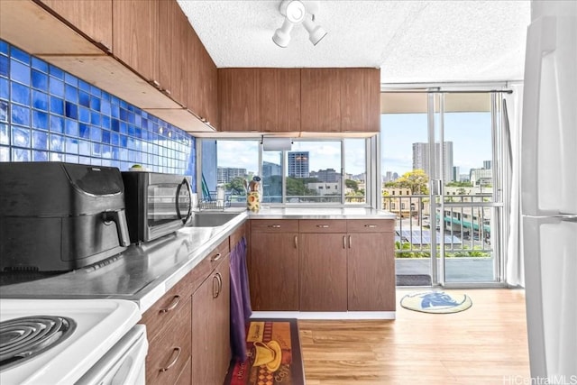 kitchen featuring a view of city, light wood-style flooring, stainless steel counters, and freestanding refrigerator