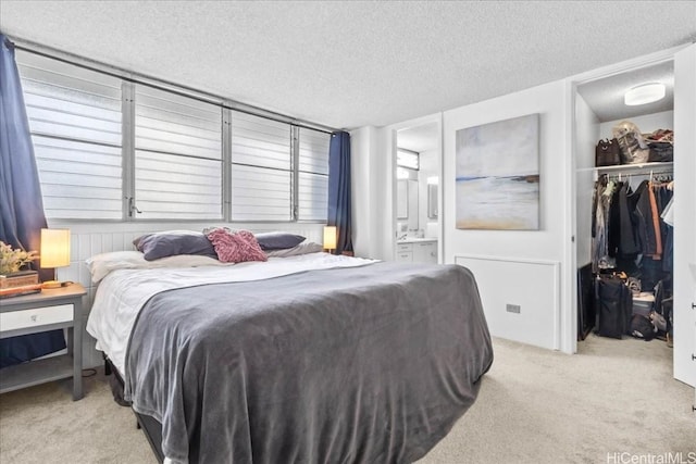 bedroom featuring a spacious closet, carpet, a closet, and a textured ceiling