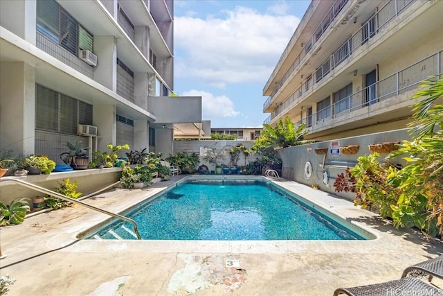 community pool with a patio area and fence