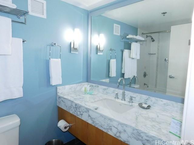 bathroom featuring vanity, toilet, and visible vents