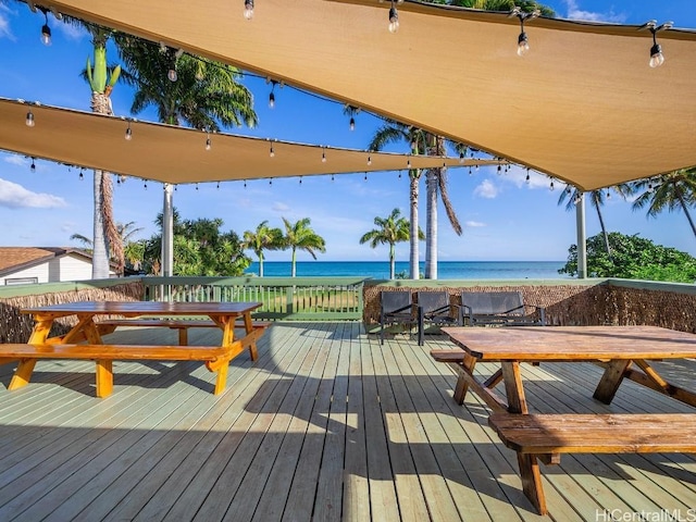 wooden deck with a water view and a beach view