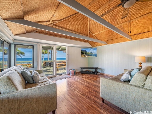 living room featuring lofted ceiling with beams, a ceiling fan, and wood finished floors