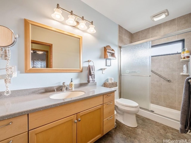 bathroom featuring toilet, a stall shower, and vanity