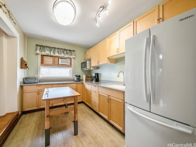 kitchen featuring light brown cabinets, a sink, light countertops, freestanding refrigerator, and light wood finished floors