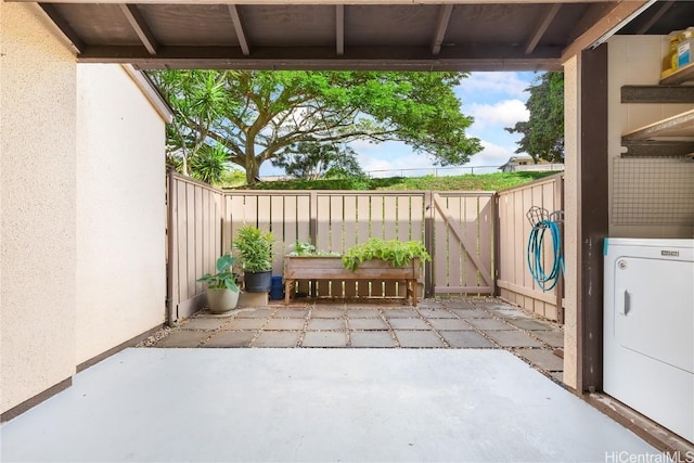 view of patio featuring washer / dryer, a gate, and fence