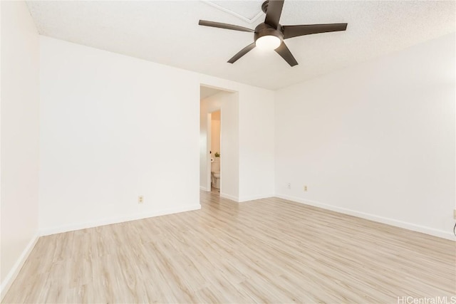 spare room featuring light wood-style floors, baseboards, and a ceiling fan