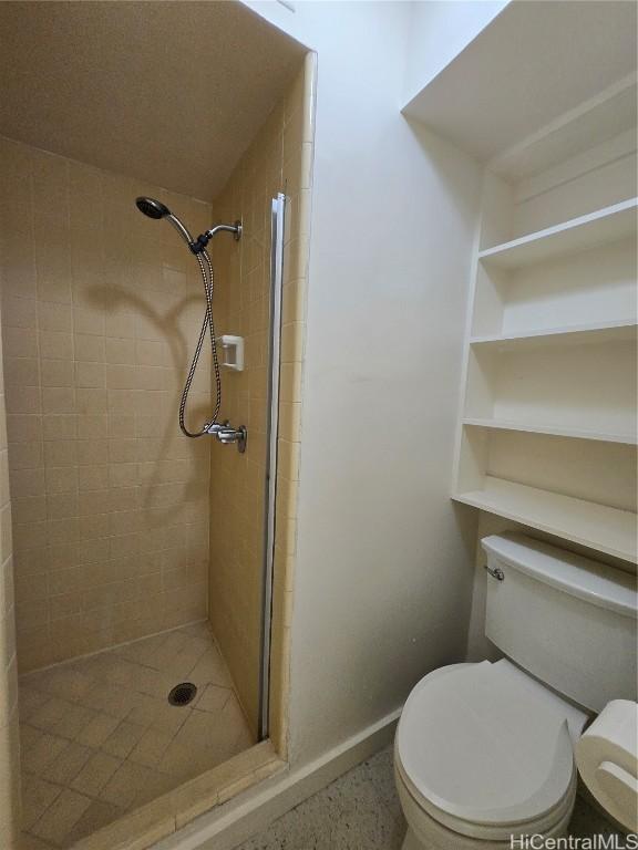 bathroom featuring toilet and a stall shower