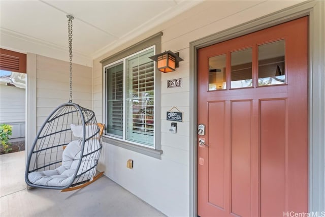 view of exterior entry featuring covered porch