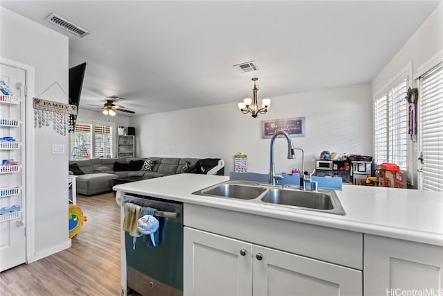 kitchen with dishwasher, light countertops, visible vents, and a sink