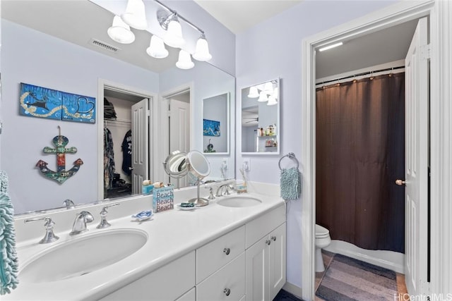 full bathroom featuring double vanity, visible vents, toilet, and a sink