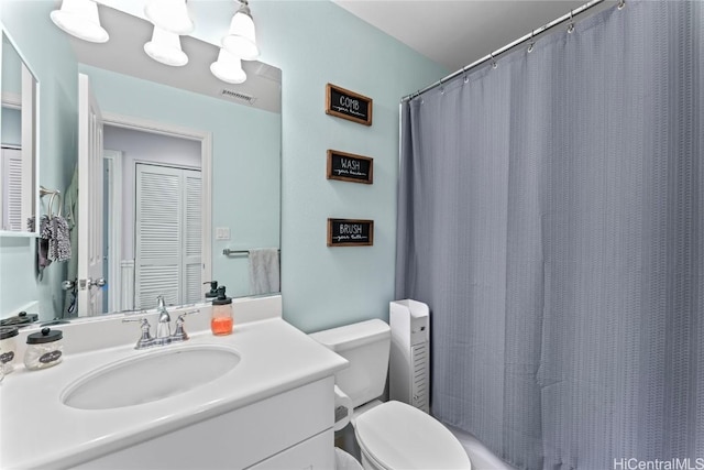 bathroom featuring vanity, a shower with shower curtain, toilet, and visible vents