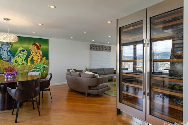 living room featuring light wood finished floors, baseboards, and recessed lighting