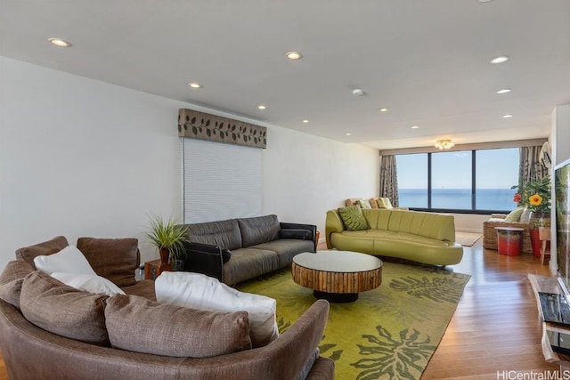 living room with a water view, wood finished floors, and recessed lighting