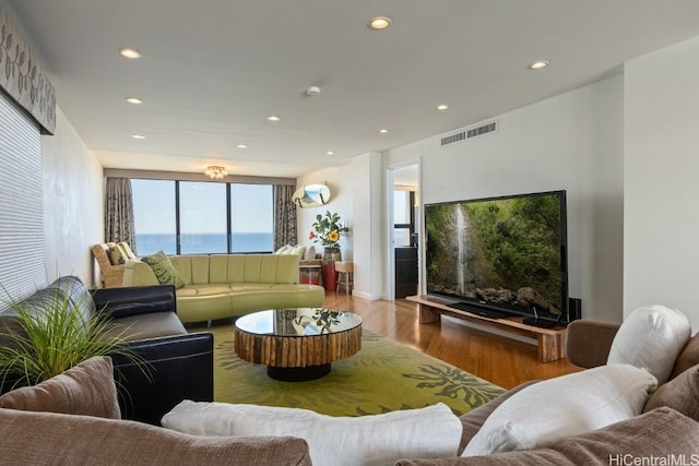 living room with recessed lighting, visible vents, and wood finished floors