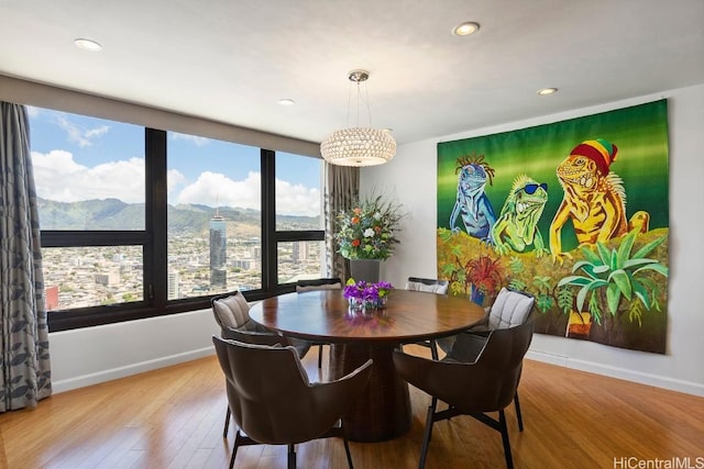 dining area featuring light wood-type flooring, baseboards, a mountain view, and recessed lighting