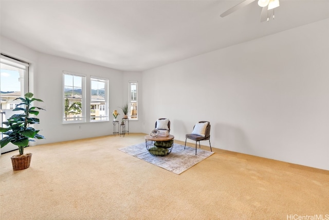 living area with carpet flooring and a ceiling fan